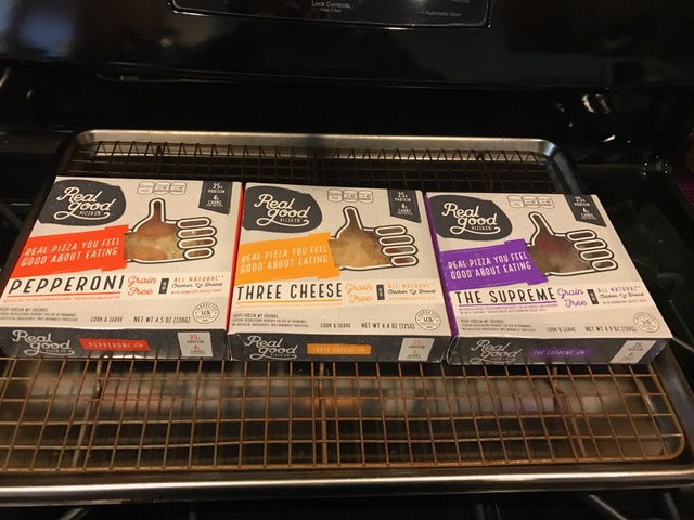 three boxed pizzas on a half sheet pan